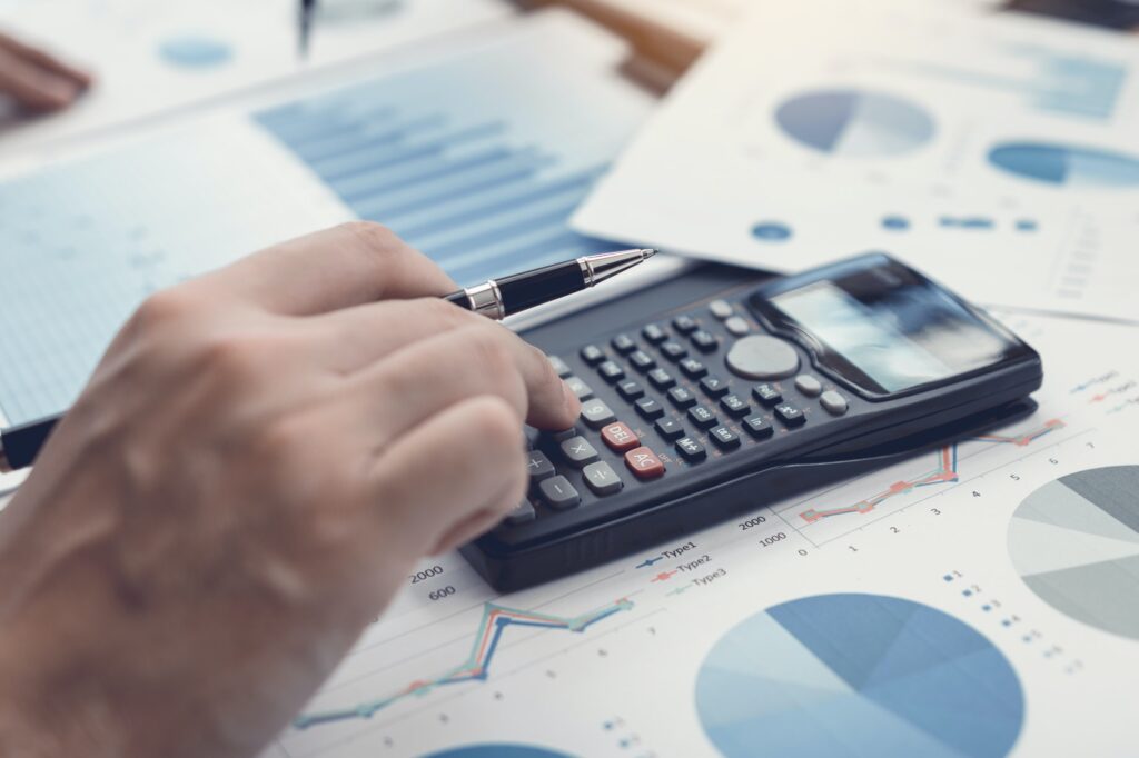 hand investors are using calculators to calculate the company's earnings to invest